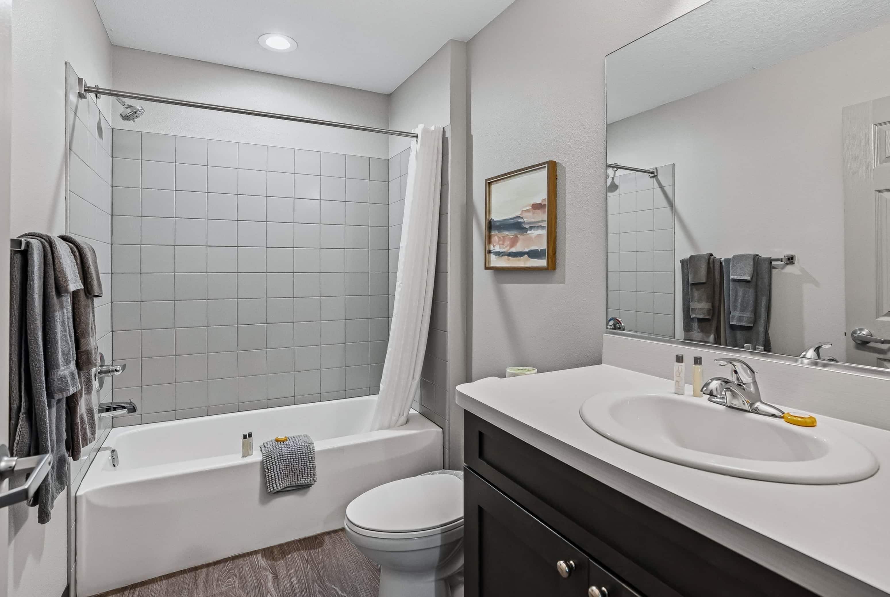 A modern bathroom with a bathtub, toilet, and sink.