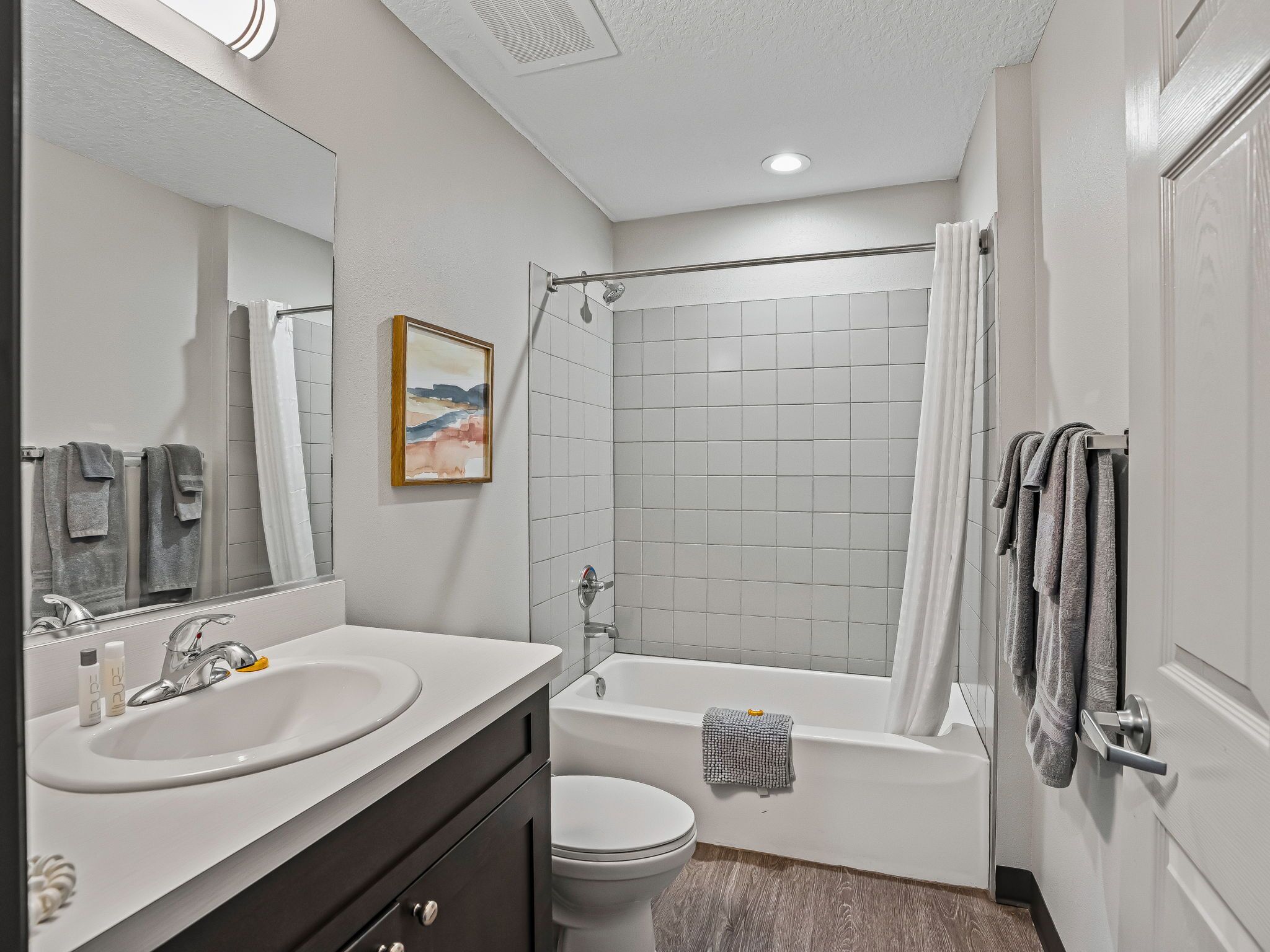 A modern bathroom with two sinks, a bathtub, and a shower.