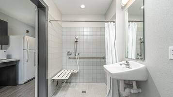 A modern bathroom with a shower, toilet, and sink.