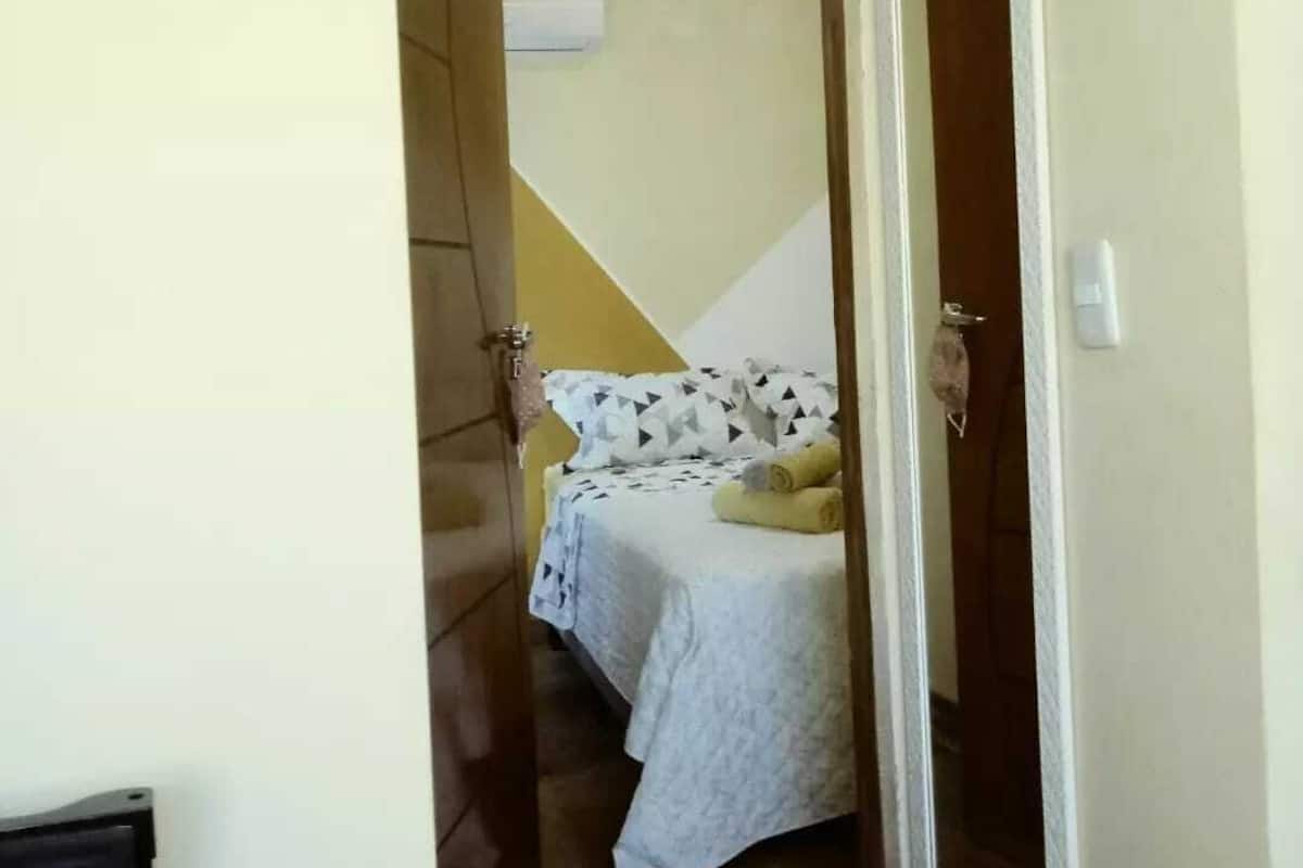Ein Schlafzimmer mit einem Bett, einem Nachttisch und einer Tür zu einem anderen Raum.