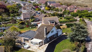 A residential area with houses, a swimming pool, and a lighthouse in the background. - Fallowfield (Great Yarmouth)