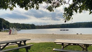 Un espacio de picnic junto al lago, con bancos y un cartel.