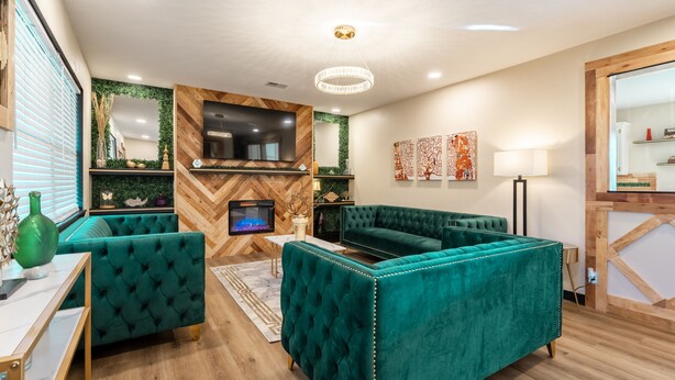 A modern living room with teal sofas, a fireplace, and a television. - Stylish and funky, minutes away from everything NWA has to offer! (Springdale)