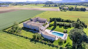 Un vaste domaine comprenant une piscine, de vastes prairies verdoyantes et un bâtiment en pierre.