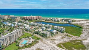 Un resort con diversi edifici, una spiaggia e un lago.