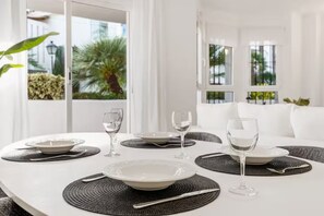Enjoy meals in style with a beautifully set table and a serene view of lush greenery.