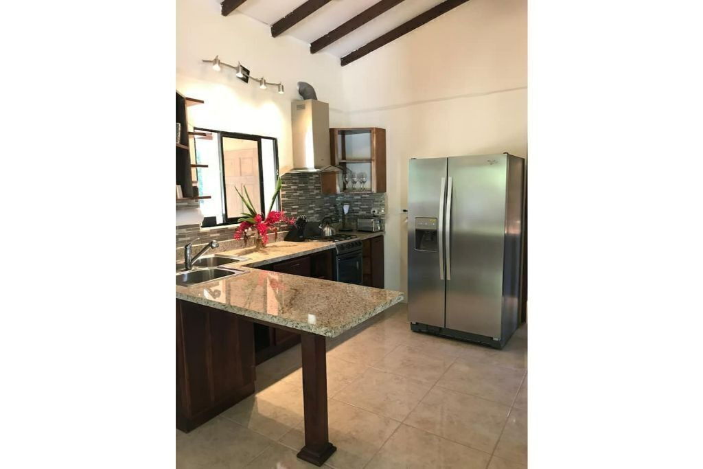 Una cocina con encimera de granito, electrodomésticos de acero inoxidable y armarios de madera oscura.