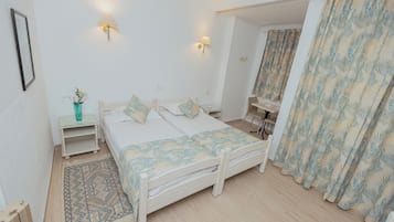 Un dormitorio con cama, mesitas de noche, un espejo y cortinas.