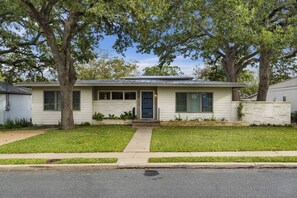 A single-story house with a front porch, a small front yard, and a driveway leading to the street.