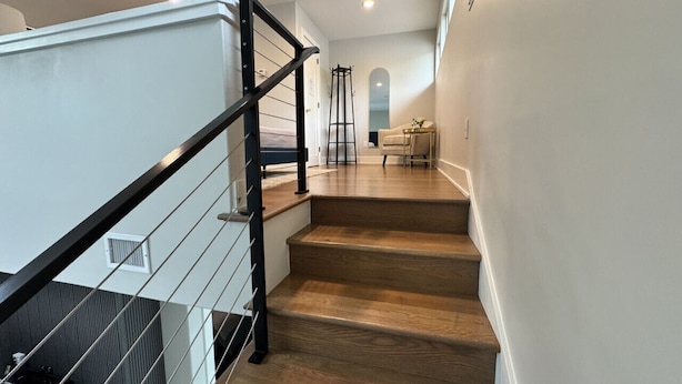 A staircase with wooden steps and a black metal railing.