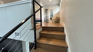 A staircase with wooden steps and a black metal railing.