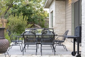 Enjoy al fresco dining and socializing in this inviting outdoor space, complete with a grill and planter.