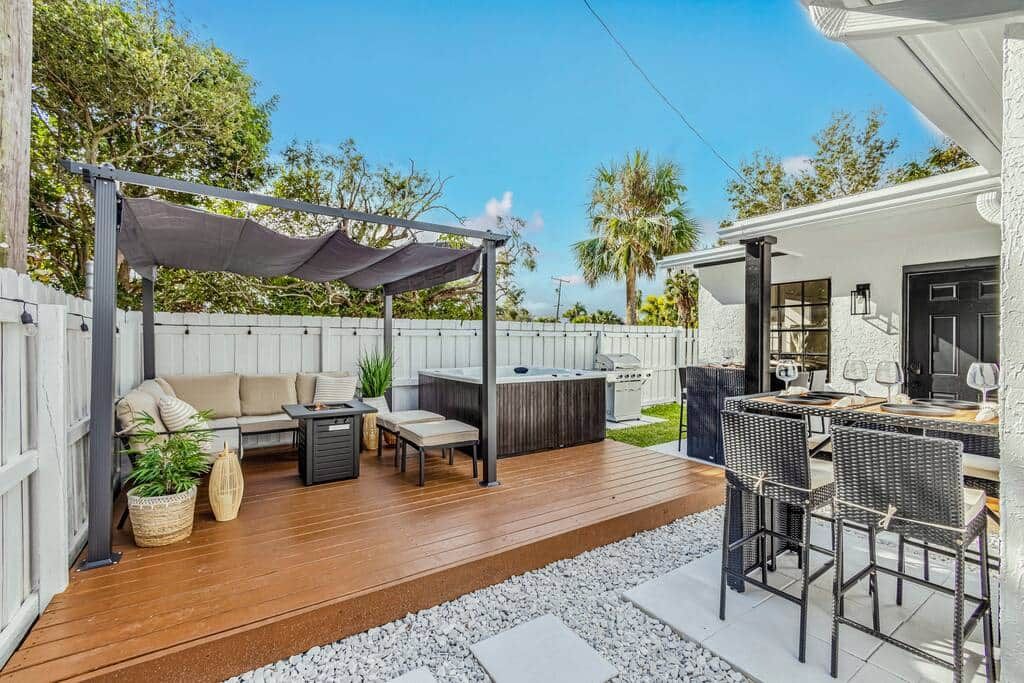 Un patio con divano, sedie, tavolo e zona barbecue.