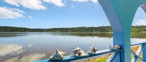 A view from a blue structure overlooking a calm lake with a clear sky.