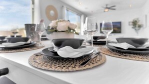 A dining table set with black bowls, white napkins, and woven placemats. - NEW 9 bd home w/Pergola|Large Gameroom|Huge Pool (Coachella)