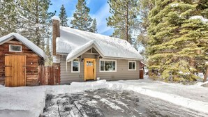 A cabin with a wooden door, a chimney, and a snow-covered roof. - Dancing Bear Cabin Pet Friendly, Sleeps 4, Totally Cute! (South Lake Tahoe)