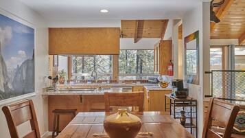 Una cocina moderna con armarios de madera, una isla grande y un comedor con mesa y sillas de madera.