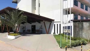 Un edificio moderno con tejado plano, ventanas grandes y un área de entrada cubierta.