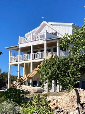 A two-story building with a balcony on the upper level and a staircase leading to the entrance.