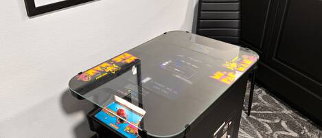 A small room with a glass-top table, a black chair, and a black cabinet.