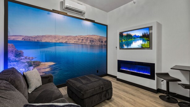 A modern living room with a large wall-mounted TV, a fireplace, and a comfortable seating area. - Icon Inn (Ellensburg)