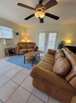 Relax in this cozy living space with a large sofa, armchair, and coffee table.
