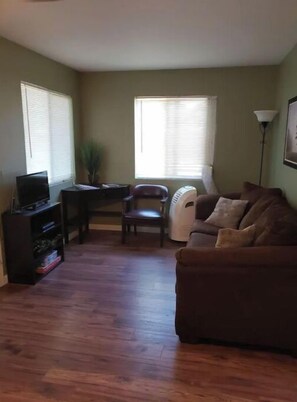 Relax in this cozy living space with a sofa, small table, and television.