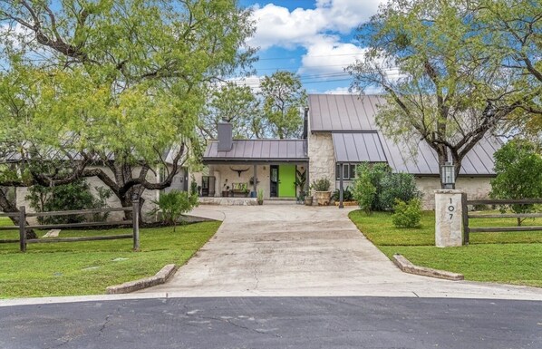 Set amidst a serene, environment, this property features a central building with a sloped roof and a clean, uncluttered design.