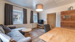 Un salon moderne comprenant un canapé, une table à manger, un téléviseur et une cheminée.
