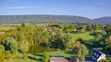 Un paysage rural avec un étang, des maisons et une grange.
