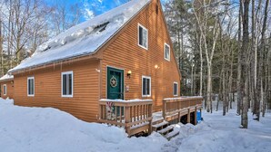 A wooden cabin with a green door, a porch, and a snow-covered roof. - Freshly done, Quiet & very comfortable house in the heart of the White Mountains (Bartlett)