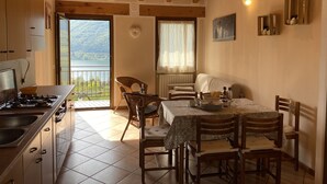 A kitchen with a stove, sink, and dining area with a table and chairs. - 2 vacation apartments for up to 6 people, perfect for a vacation with family or friends (Idro)