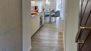 A modern kitchen with a central island, a dining area with two chairs, and a view of the outdoors through a window. - 2 vacation apartments for up to 6 people, perfect for a vacation with family or friends (Idro)