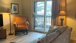 A living room with a sofa, armchair, and a ceiling fan.