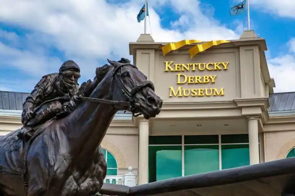 El Museo del Kentucky Derby con una estatua de un jinete a caballo frente al edificio.