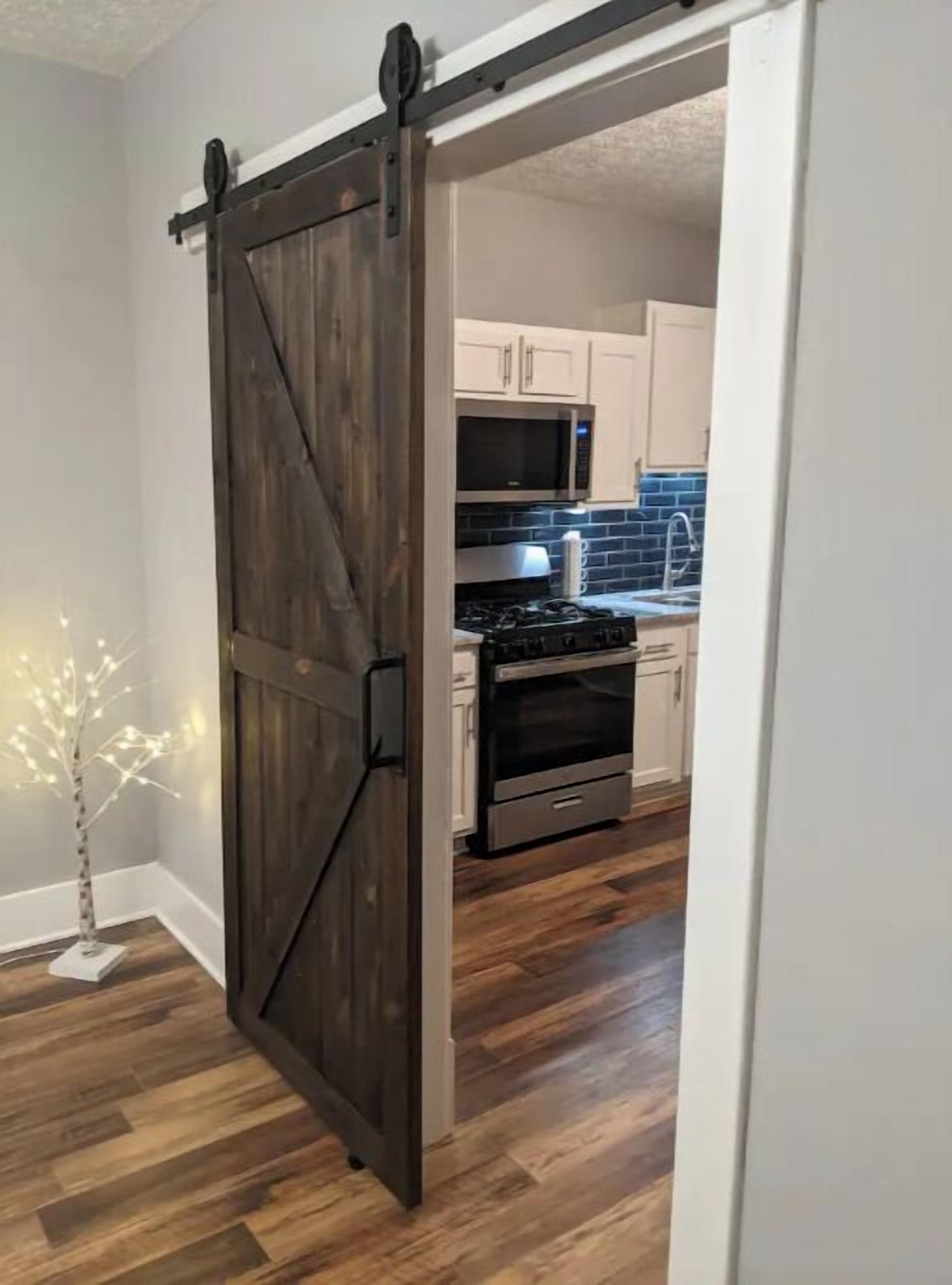 A kitchen with white cabinets, a microwave, stove, and oven.