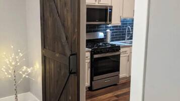 A kitchen with white cabinets, a microwave, stove, and oven.