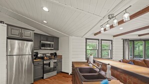 Una cocina moderna con electrodomésticos de acero inoxidable, suelo de madera y una isla grande con pileta.