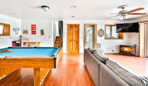 A room with a pool table, a sofa, a fireplace, and a television. - Log Cabin Hot tub Private Pool 360 Mountain Views Hunter Mt (Tannersville)
