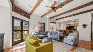 A spacious living room with a large sectional sofa, a yellow armchair, and a ceiling fan. - SPANISH TRADITIONAL - MOVIE COLONY EAST;  PS City ID #038084 (Palm Springs)