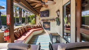 A cozy outdoor seating area with a fire pit, comfortable cushions, and a ceiling fan. - SPANISH TRADITIONAL - MOVIE COLONY EAST;  PS City ID #038084 (Palm Springs)
