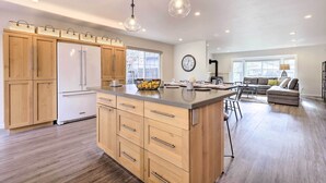 A spacious kitchen with wooden cabinets, a large island, and pendant lighting. - Peaceful Windsor Retreat w/ Private Hot Tub! (Windsor)