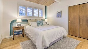 Una camera da letto con un letto, comodini, una finestra e un armadio.