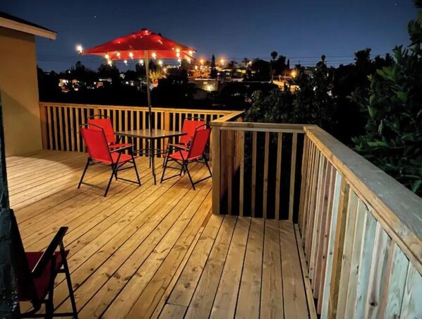 Enjoy a quiet evening on the deck with a table and chairs, shaded by an umbrella.