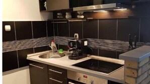 Una cocina moderna con baldosas blanco y negro, electrodomésticos de acero inoxidable y una pared de ladrillo decorativa.