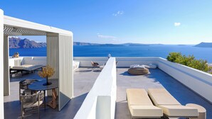 A rooftop terrace with a view of the sea, outdoor seating, and a table with chairs. - Oia Treasures Art Suites (Santorini)