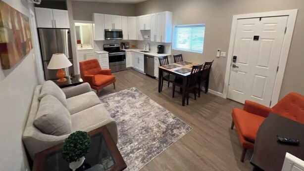 A compact living space with a kitchenette, dining area, and seating area. - Stylish and cozy 2 bed (Brighton)