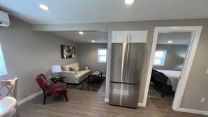 A compact living space with a kitchenette, a dining area, and a bedroom.