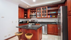 Une cuisine avec des meubles en bois, un réfrigérateur en acier inoxydable, un four à micro-ondes et un lave-vaisselle.