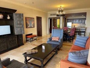 Relax in this inviting living space with a plush sofa, comfortable armchair, and dark wooden coffee table.
